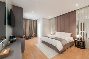 a bedroom with a large bed and a flat screen tv at Troci Hotel in Tirana