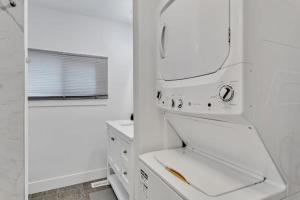 une cuisine blanche avec une cuisinière et un évier dans l'établissement Dorado at The Kabins by The Falls, à Fenelon Falls 28 autres photos