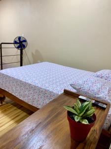 1 dormitorio con cama y mesa con maceta en Verde Amanecer en Bijagua