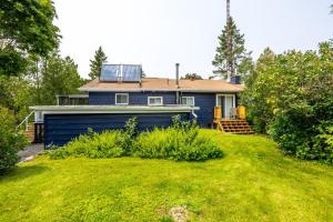 une maison bleue au milieu d'une cour dans l'établissement Dorado at The Kabins by The Falls, à Fenelon Falls