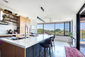 an open kitchen with a large island with bar stools at SALT Luxury Couples Villa in Venus Bay
