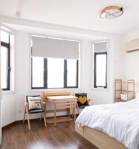 a bedroom with a bed and a table and chairs at 1930 French Minimalist Apartment in Shanghai