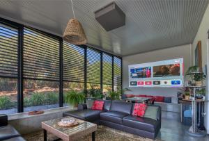 a living room with a couch and large windows at SALT Luxury Couples Villa in Venus Bay