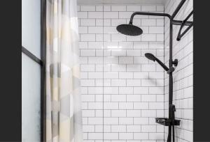 a shower with a shower curtain and a shower head at 1930 French Minimalist Apartment in Shanghai