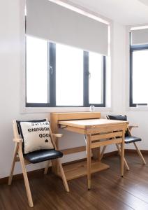 a table and a chair in a room with windows at 1930 French Minimalist Apartment in Shanghai