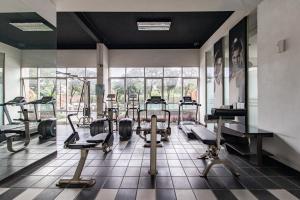 a gym with treadmills and machines in a room at The Edge by Lia in Cimindi-hilir
