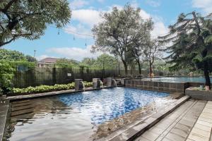 une piscine dans une arrière-cour avec une clôture et des arbres dans l'établissement The Edge by Lia, à Cimindi-hilir