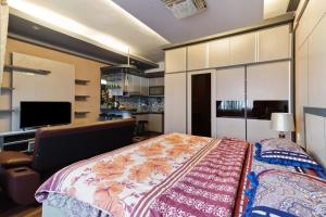 a bedroom with a bed and a flat screen tv at The Edge by Lia in Cimindi-hilir