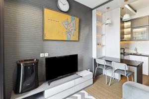 a living room with a television and a dining room at The Edge by Lia in Cimindi-hilir