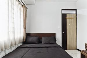 a bedroom with a bed with a wooden headboard at The Edge by Lia in Cimindi-hilir