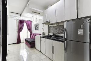 a kitchen with a stainless steel refrigerator and a couch at The Edge by Lia in Cimindi-hilir
