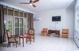 パシフィック・ハーバーにあるYatu Lau Lagoon Resort Fijiのリビングルーム(椅子、テーブル、天井ファン付)