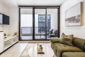 uma sala de estar com um sofá e uma grande janela em Central & Stylish in St Kilda w AC, WiFi & Balcony em Melbourne