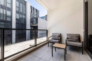 um apartamento varanda com duas cadeiras e uma mesa em Central & Stylish in St Kilda w AC, WiFi & Balcony em Melbourne