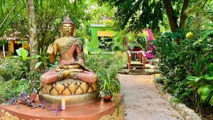 eine Buddha-Statue, die in einem Garten sitzt in der Unterkunft Gardenhotel Macan Ché B&B in Izamal + 10 Fotos