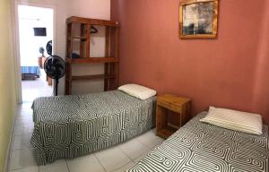 a room with two beds and a shelf at Point do Rio Vermelho in Salvador