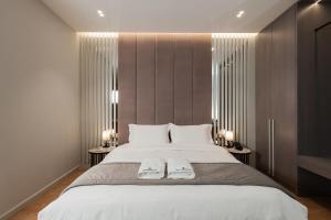 a bedroom with a large bed with two towels on it at Troci Hotel in Tirana