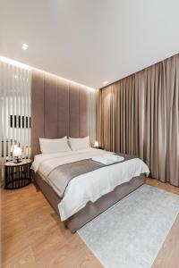 a bedroom with a large bed and a large window at Troci Hotel in Tirana