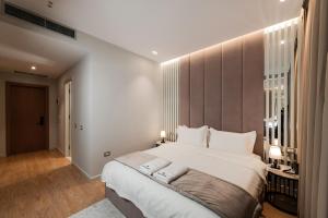 a bedroom with a large white bed with white pillows at Troci Hotel in Tirana