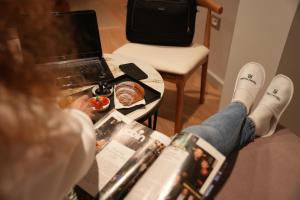 a woman laying on a table in front of a laptop at Troci Hotel in Tirana