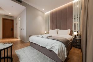 a bedroom with a large bed and a table at Troci Hotel in Tirana