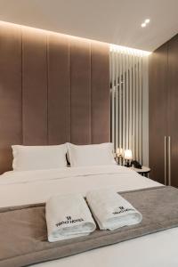 a bedroom with a large bed with two towels on it at Troci Hotel in Tirana