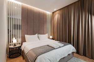 a bedroom with a large bed with curtains at Troci Hotel in Tirana
