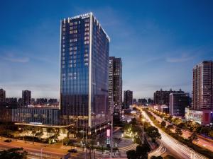wysoki budynek w mieście w nocy w obiekcie Courtyard by Marriott Changsha South w mieście Changsha