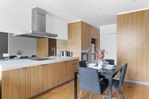 een keuken en eetkamer met een tafel en stoelen bij Modern 2BR Apt Next to Southern Cross FREE Parking in Melbourne
