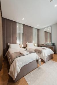 a bedroom with two beds and a mirror at Troci Hotel in Tirana