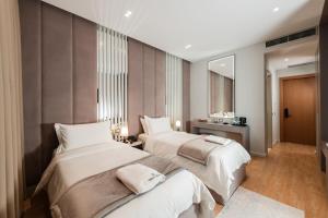 a bedroom with two beds and a mirror at Troci Hotel in Tirana