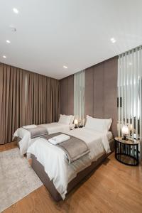 a large bedroom with two beds and two tables at Troci Hotel in Tirana