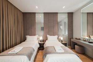 two beds in a hotel room with mirrors at Troci Hotel in Tirana