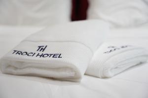 a pile of towels sitting on top of a bed at Troci Hotel in Tirana