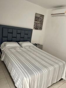 a bedroom with a large bed with a striped blanket at Hermosa casa in Cúcuta