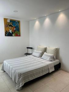 a bedroom with a large bed with white sheets at Hermosa casa in Cúcuta +9 photos