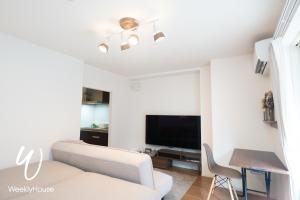 a living room with a couch and a flat screen tv at WeeklyHouse Silto Crete - Vacation STAY 14148v in Otsu