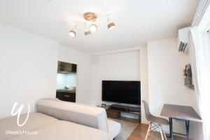 uma sala de estar com um sofá e uma televisão de ecrã plano em WeeklyHouse Silto Crete - Vacation STAY 14148v em Otsu