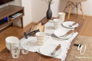 una mesa de comedor con platos y cubiertos en WeeklyHouse Silto Crete - Vacation STAY 14148v, en Otsu