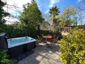 a hot tub in a yard with a table and chairs at Porters Cottage Garden in Albury