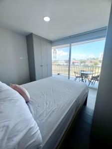 a bedroom with a bed with a view of a balcony at Departamento al pie del mar - Punta Blanca in Punta Blanca
