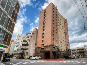 a tall brick building on a city street at GRG Hotel Naha in Naha