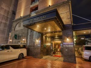 a white car parked in front of a building at GRG Hotel Naha in Naha