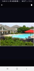 a picture of a pool with a red umbrella at Long Term Retreat Haven in Chapel Hill