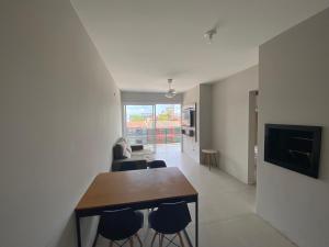 a living room with a dining room table and chairs at Ótimo Ap a 50m da areia Churrasq 2Q 2banheiros in Torres