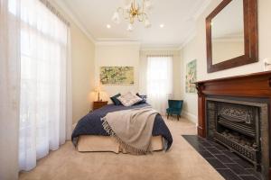 a bedroom with a bed and a fireplace at Porters Cottage Classic in Albury
