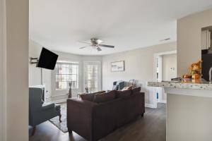 a living room with a brown couch and a kitchen at Center City Charm, the place to meet all of your needs in Huntsville