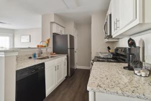 a kitchen with white cabinets and a black refrigerator at Center City Charm, the place to meet all of your needs in Huntsville