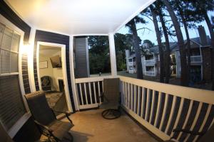 a balcony with two chairs and a view of a street at Center City Charm, the place to meet all of your needs in Huntsville