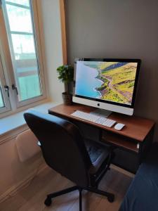 a computer monitor sitting on a desk with a chair at Elegant private room Oslo Central - Grunerløkka 1km from Oslo S Station in Oslo
